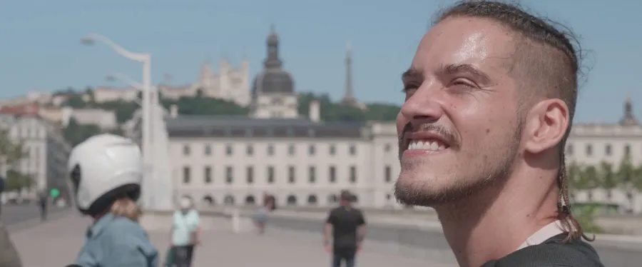 Thomas, un jeune homme en t-shirt noire, fait du vélo adapté sur les bords du Rhône à Lyon